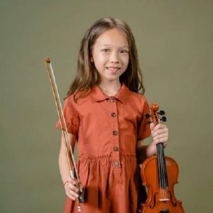 child holding onto a violin